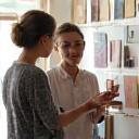 En stylist rådgiver en kunde med et moodboard for indretningsforslag.